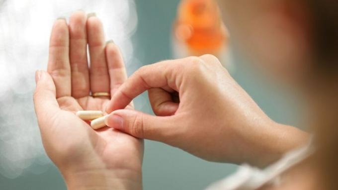 Жена с ADHD държи хапчета риталин в дланта