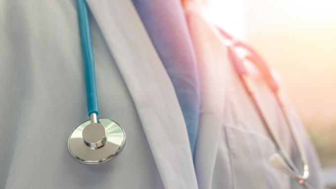 Лекар или лекар в бяла рокля в униформа със стетоскоп в болница или клиника