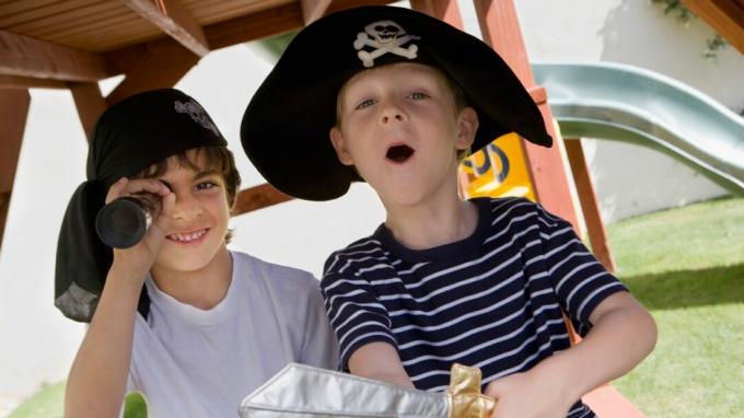 Две момчета с ADHD играят пирати на детска площадка в костюми